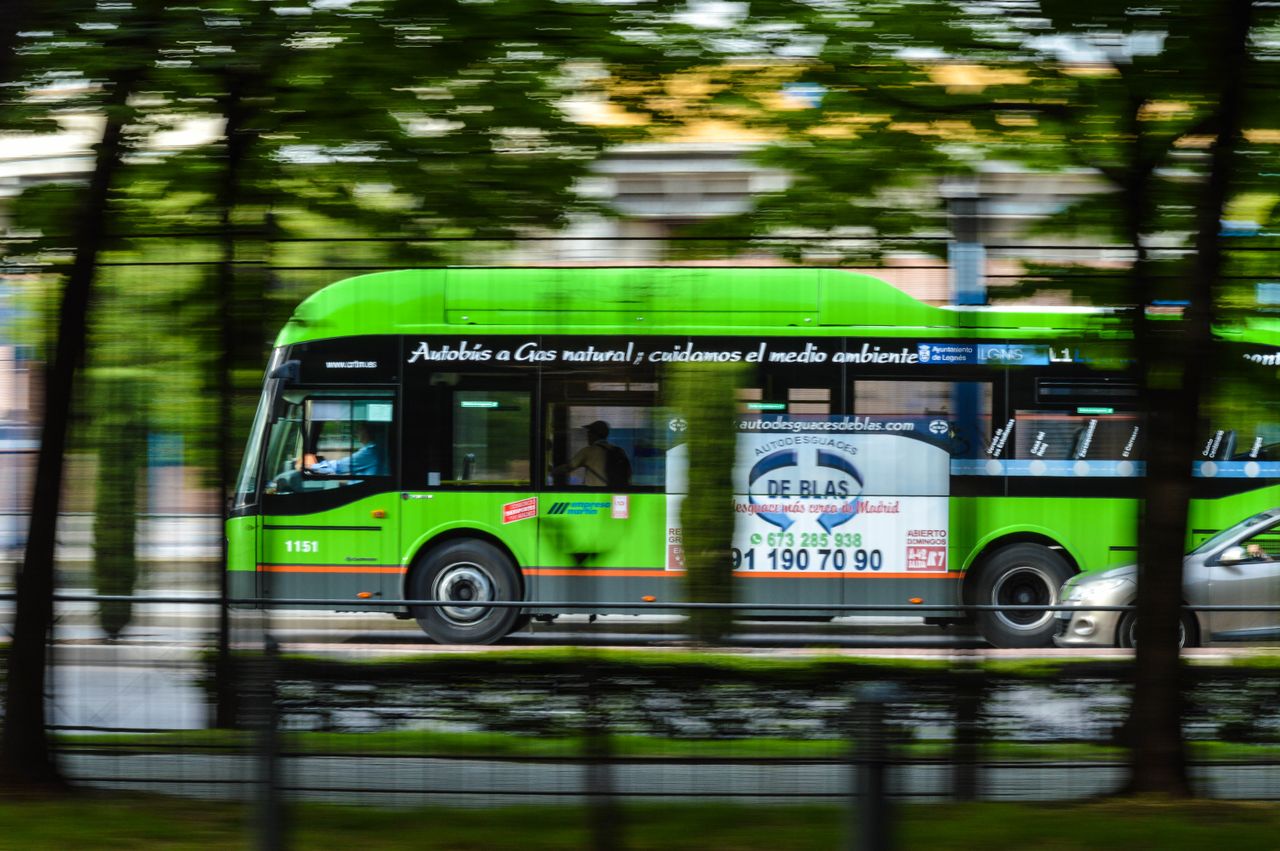 Crafting Captivating Headlines: Your awesome post title goes here A green natural gas bus in motion on a city street, emphasizing eco-friendly transportation.